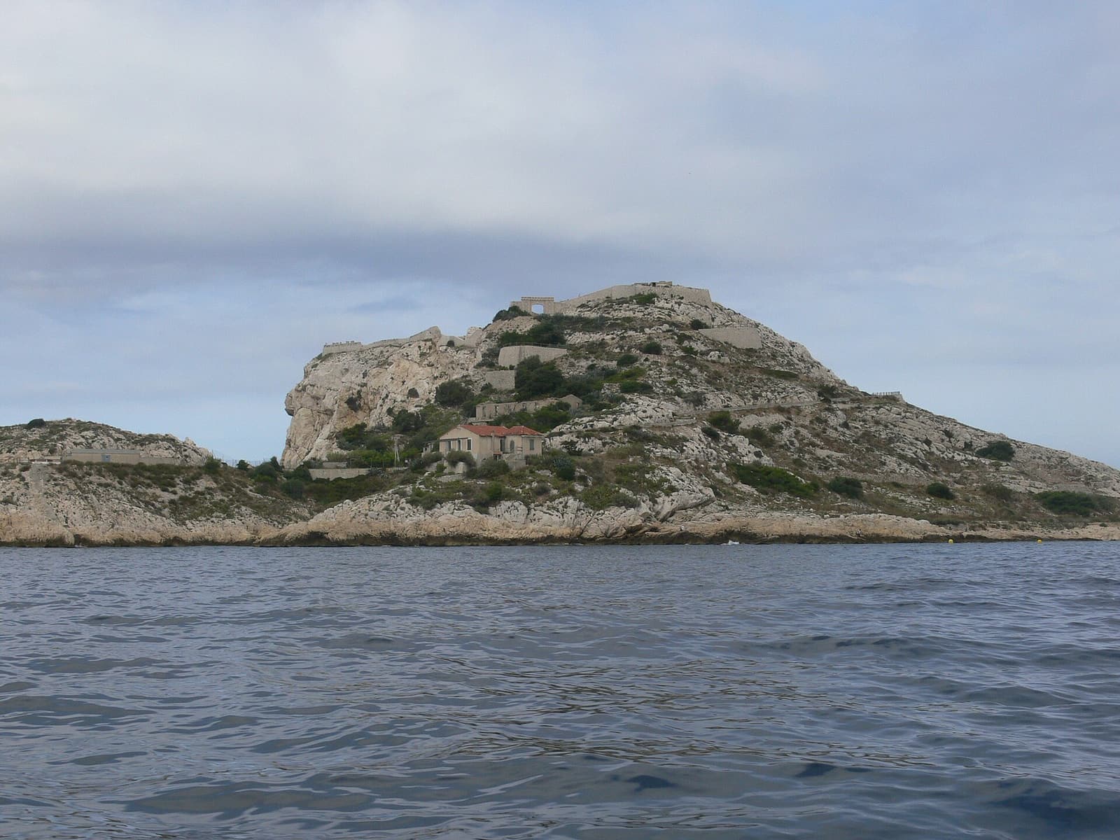 Gesamtansicht der Île Ratonneau, einer kahlen weißen Kalksteininsel in ruhigem blauem Meer