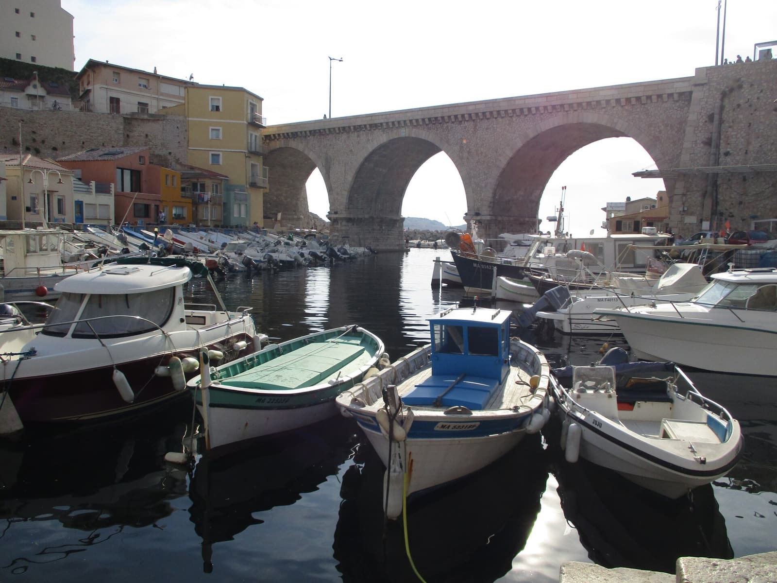 Kleine Fischerboote im Vallon des Auffes unter der steinernen Bogenbrücke