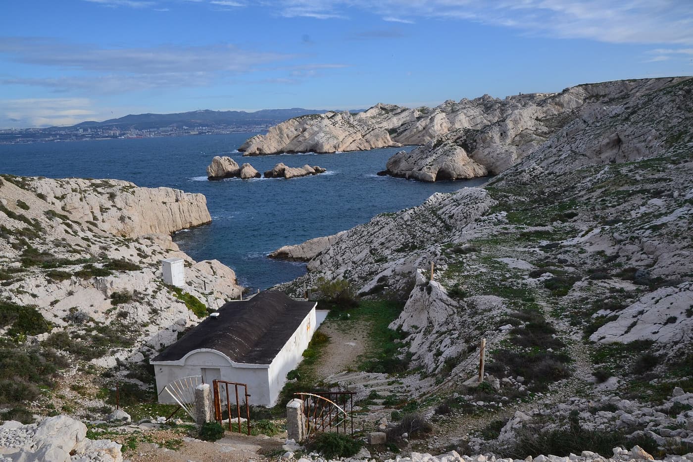 Clear water in a rocky cove on the Frioul islands with limestone cliffs behind