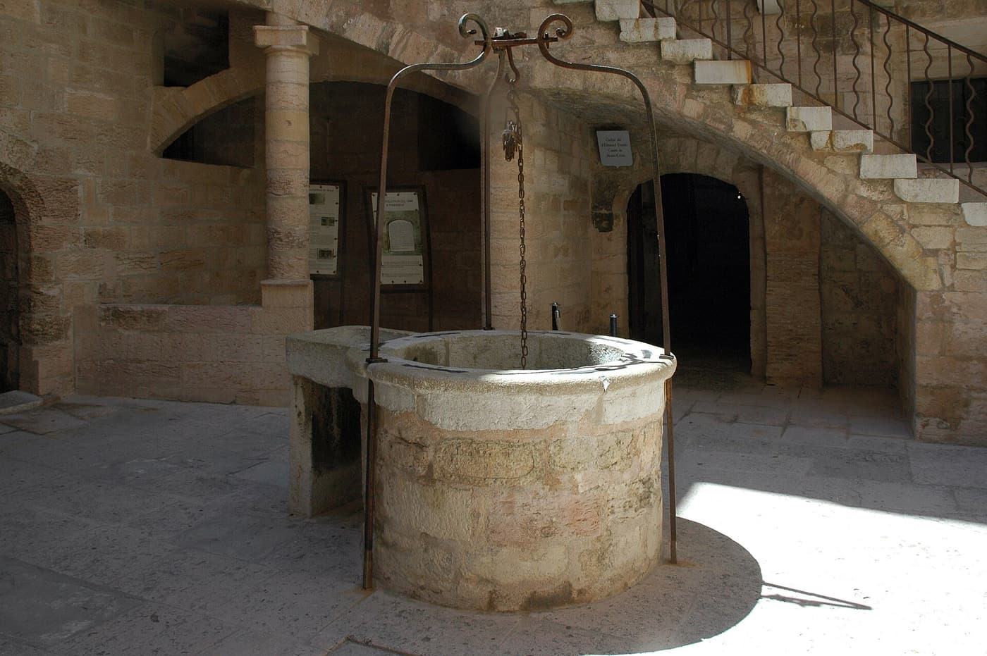 Der steinerne Brunnen im Innenhof des Château d’If mit Arkaden und Steintreppe